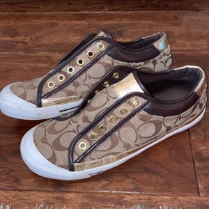 Gold and White Coach Slip On sneakers.
